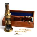A lacquered brass student's microscope and slides in original mahogany case.