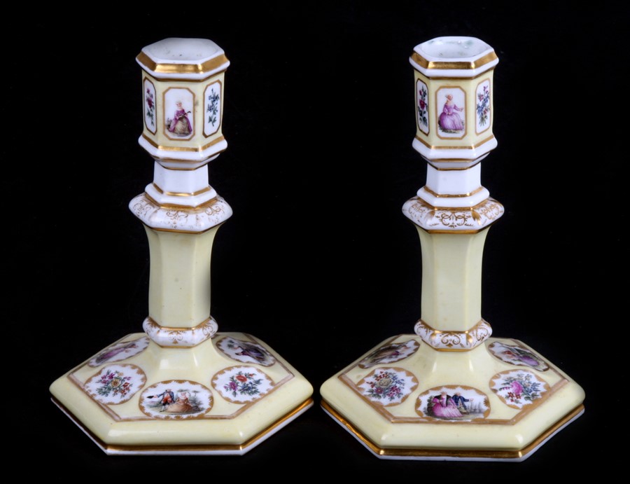 A pair of mid 19th century Paris porcelain candlesticks, a primrose yellow ground with enamelled