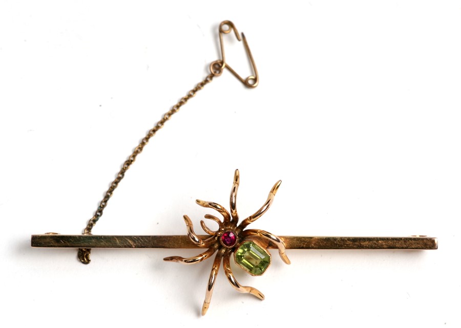 A large 9ct gold stock pin having a gem set spider to the centre, weight 7.4g, 7.5cms (3ins) wide.