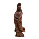A Chinese boxwood carving in the form of Guanyin holding a vase, 46cms (18ins) high; together with a