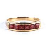 A 9ct gold ring set with six square cut garnets, approx UK size 'O'.