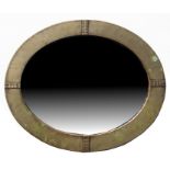 An Arts & Crafts Liberty & Co. style oval brass framed wall mirror, 52 by 63cms (20.5 by 24.75ins).