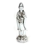 A Chinese Blanc de Chine style figure, depicting Guan Yin carrying a small child holding a rui