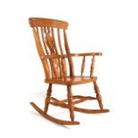 A country farmhouse beech rocking chair with pierced splat and turned supports.