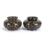 A pair of Persian style pottery vases of compressed globular form, decorated with flowers, 18cms (