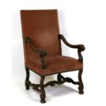 A continental throne chair with upholstered seat and back, the arms carved with acanthus leaf and