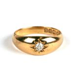 An 18ct gold gypsy style ring set with a single diamond, approx UK size 'K'.