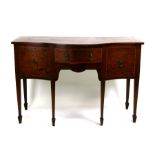 A late 19th century mahogany serpentine fronted sideboard with central drawer flanked by a
