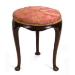 A mahogany circular stool with upholstered seat, on three cabriole legs.