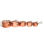 A set of five graduated Helvetia copper saucepans, the largest 24cms (9.5ins) diameter.