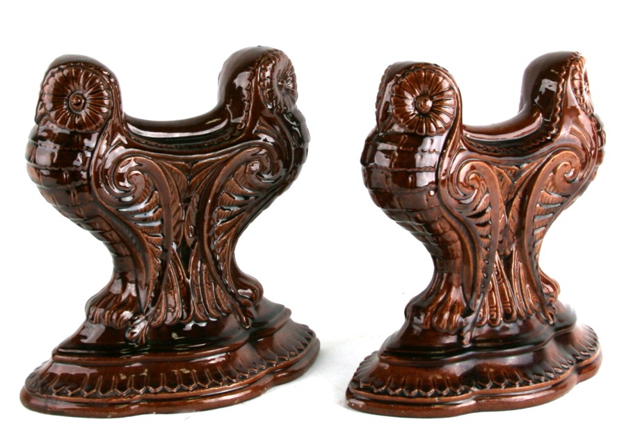 A pair of treacle glaze fire dogs in the form of owls, 24cms (9.5ins) high.