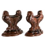 A pair of treacle glaze fire dogs in the form of owls, 24cms (9.5ins) high.
