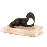 A contemporary painted carved wooden figure of an otter, overall 25cms (9.75ins) wide.