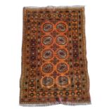 A Persian Bokhara rug with two rows of five central medallions on a burnt orange ground, 77 by