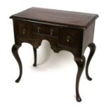 A walnut lowboy, the rectangular crossbanded top above a central frieze drawer with two deep drawers