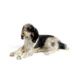 A cold painted bronze figure of a recumbent spaniel, 6cms (2.25ins) long.