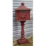 A red painted cast post box decorated with a horse and rider, 115cms (45ins) high.