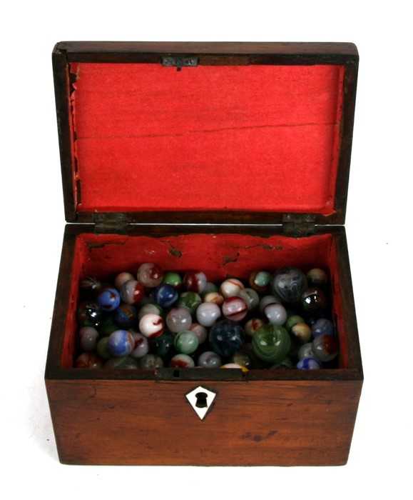 A quantity of vintage marbles in a mahogany box.