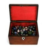 A quantity of vintage marbles in a mahogany box.