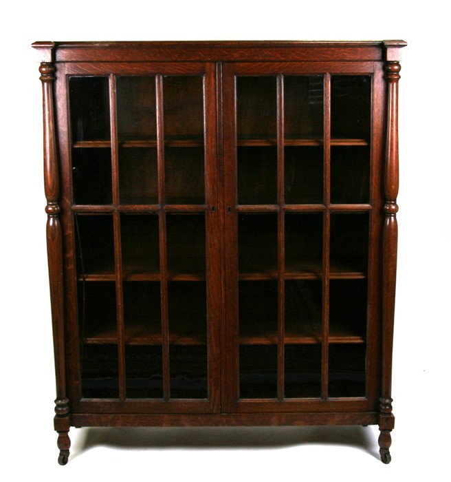 An oak glazed bookcase with shelved interior,