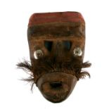 African / Tribal Art. An African wooden mask with hammered metal eyes and applied red cloth to the