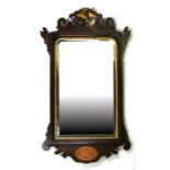 A 19th century mahogany mirror with shell inlay, surmounted with a Hoho bird, 51cms (20ins) wide.