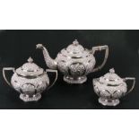 A Burmese white metal three-piece tea set highly decorated with animals within panels, total