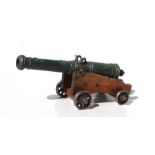 A 20th century signal cannon with antique effect barrel mounted on a wooden carriage with metal