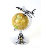A decorative world globe surmounted with a jet plane, 29cms (11.5ins) high.