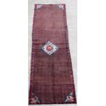 A Persian Kordi woollen hand knotted runner with central geometric gul on a blue ground, 285 by