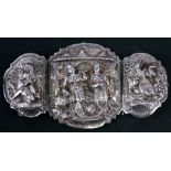 A three-piece Burmese white metal buckle decorated in high relief with figures, 14cms (5.5ins)