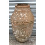 A large terracotta olive jar with crimped banded decoration, 66cms (26ins) high.