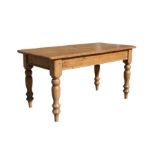 A stripped pine rectangular kitchen table on turned legs, 153cms (60ins) long.