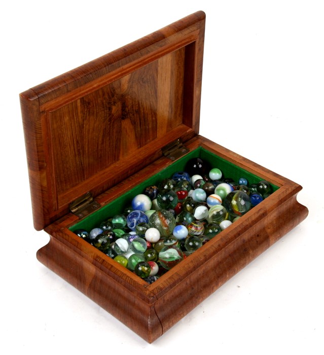 A quantity of vintage marbles in a mahogany box.