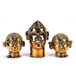 A group of three probably 19th century Indian polished bronze deity heads, the largest 20cms (