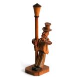 An Anri carved wooden novelty bottle opener modelled as a drunken man holding onto a lamp post,