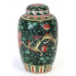 A Chinese famille verte vase and cover decorated with dragons and flowers on a black ground,