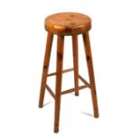 A pine kitchen stool on turned legs.