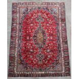 A Persian Mashad woollen hand knotted carpet with central floral medallion within floral borders