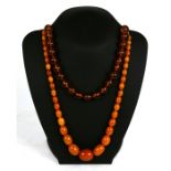 A butterscotch amber graduated oval bead necklace, weight 44g; together with a clear amber round