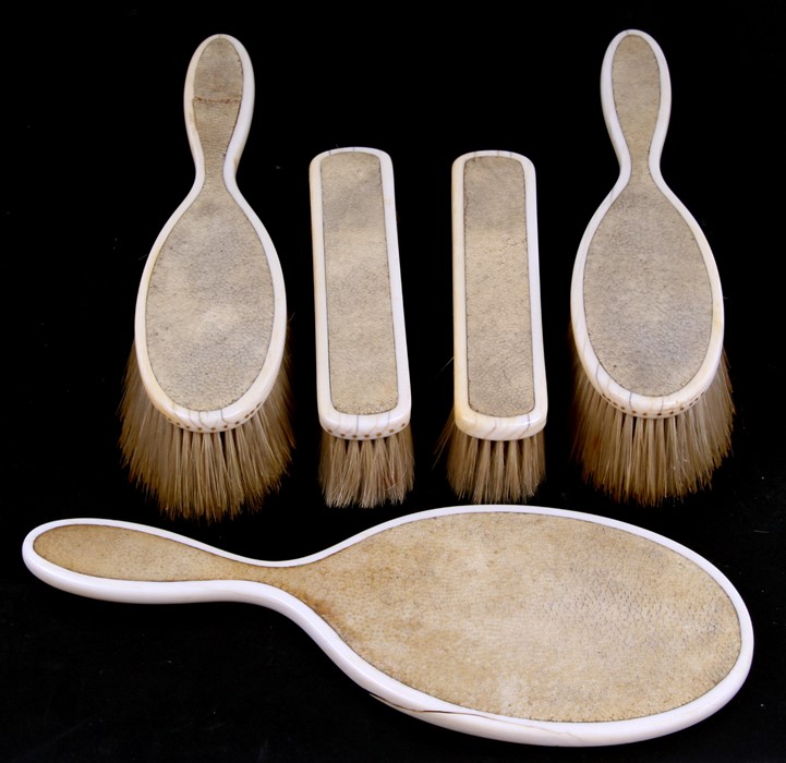 An early 20th century shagreen and ivory dressing table set consisting of a hand mirror and four