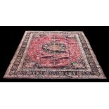 A Persian Mashad woollen hand knotted carpet with central floral medallion on a red ground, 372 by