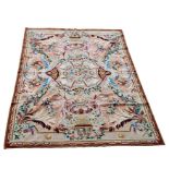 An Aubusson style rug with central motif surrounded by foliate scrolls, on a beige ground, 160 by