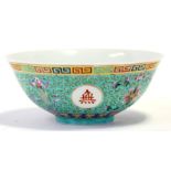 A 20th century Chinese famille rose bowl decorated with foliate scrolls on a green ground, 19cm (7.