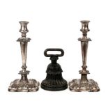 A pair of silver plated candlesticks; together with a cast iron doorstop (3).
