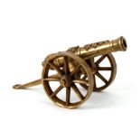 A cast brass signal cannon mounted on a brass carriage and wheels. Barrel length 24.5cms (9.75ins)