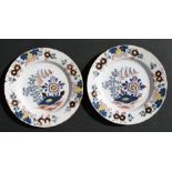 A pair of 18th century Delft plates decorated with flowers, 23cm (9ins) diameter.