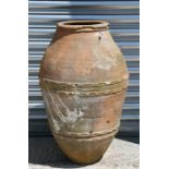 A large terracotta olive jar, 58cm (22.75ins) high