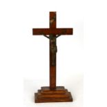 A bronzed spelter figure of Christ on an oak cross, 42cms (16.5ins) high.