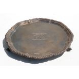 A silver salver on scroll feet, indistinct Sheffield hallmarks, inscribed, weight 596g, 26cms (10.